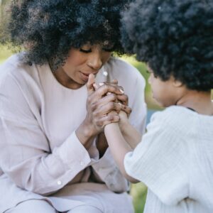 a woman and a young girl praying together
